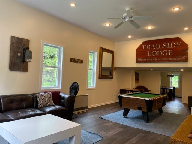living room with couches, pool table, seating areas